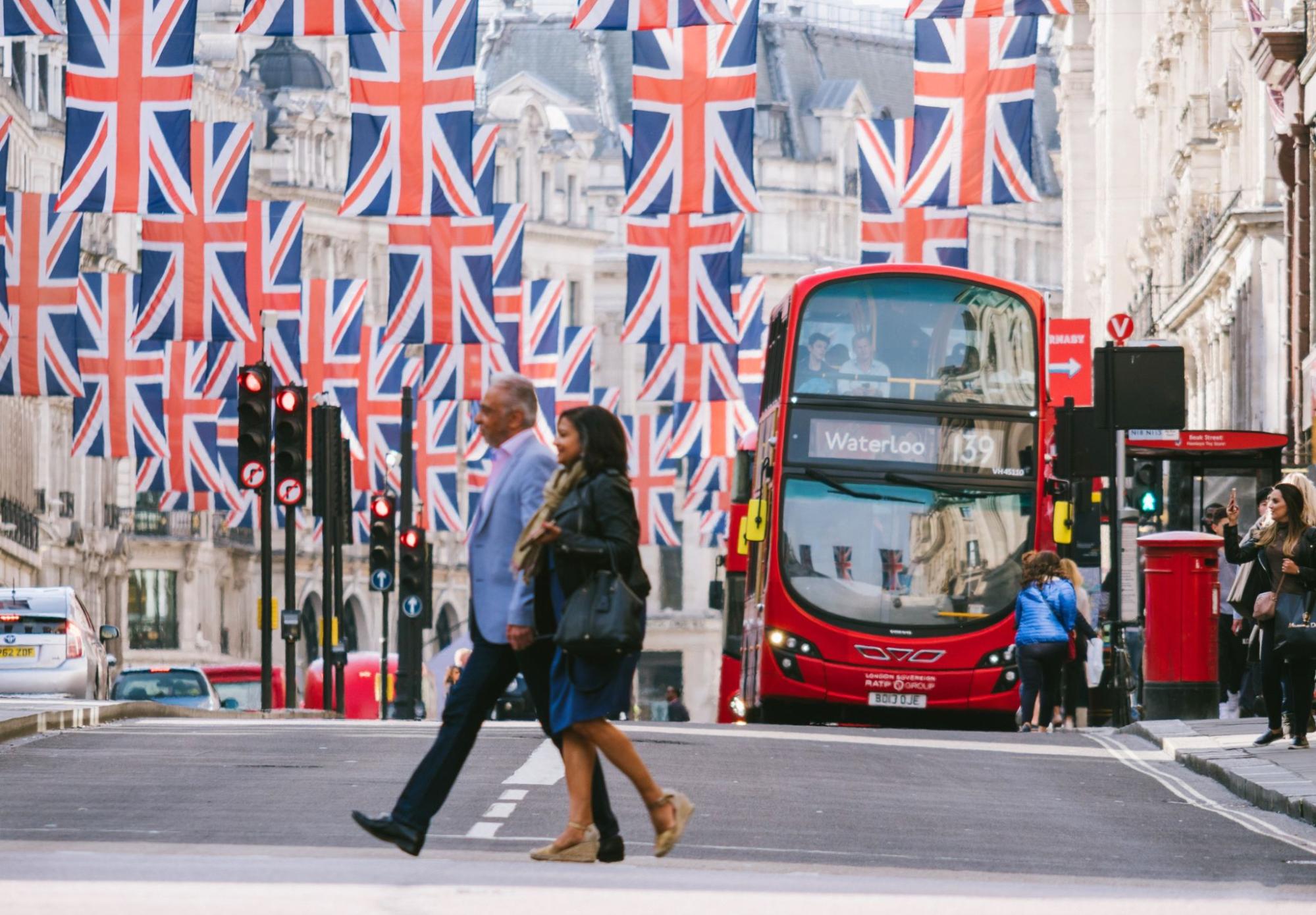Couple under Union Jack Flags on Regent Street a day before Royal Wedding. The Royal Wedding between Prince Harry and Meghan Markle